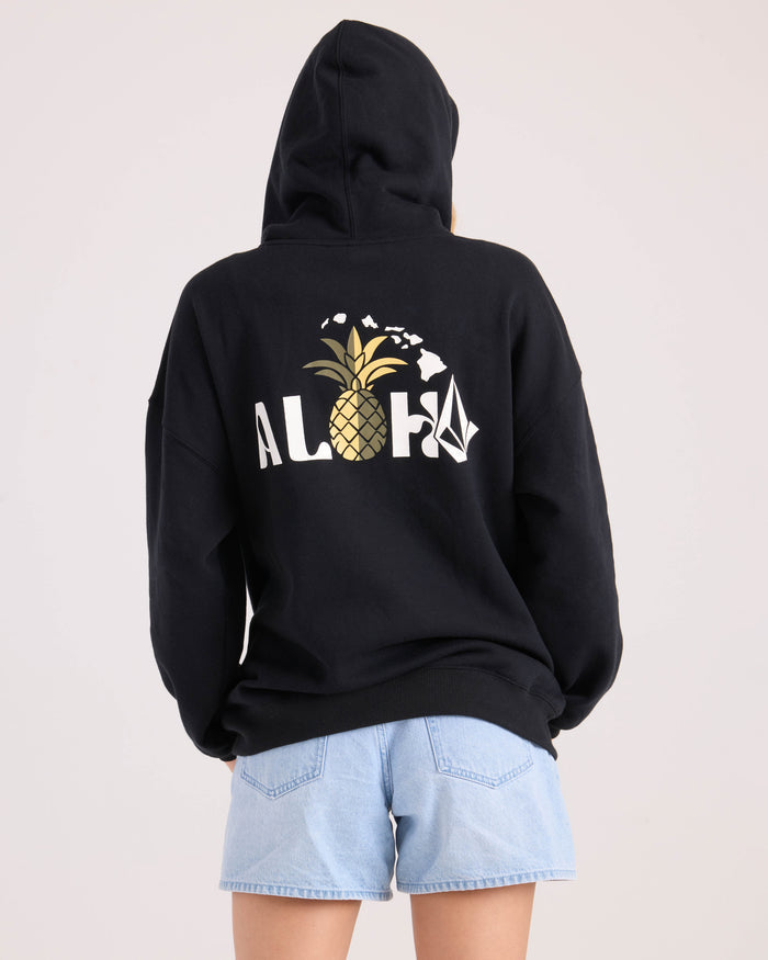 A woman wearing the Volcom Women's Haleiwa hoodie is shown from behind against a plain background, pairing the relaxed-fit fleece with light blue denim shorts for a casual, comfortable look.