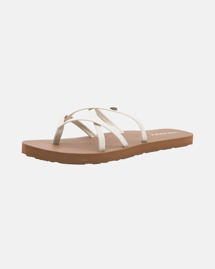The Volcom Women's New School II sandal features a flat brown sole with molded arch support and white synthetic leather crisscross straps, displayed at an angle on a plain white background.