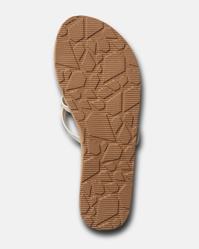 The image shows the bottom sole of the Volcom Women's New School II sandal, featuring a light brown textured pattern with geometric shapes and lines on a white background, plus molded arch support for comfort.