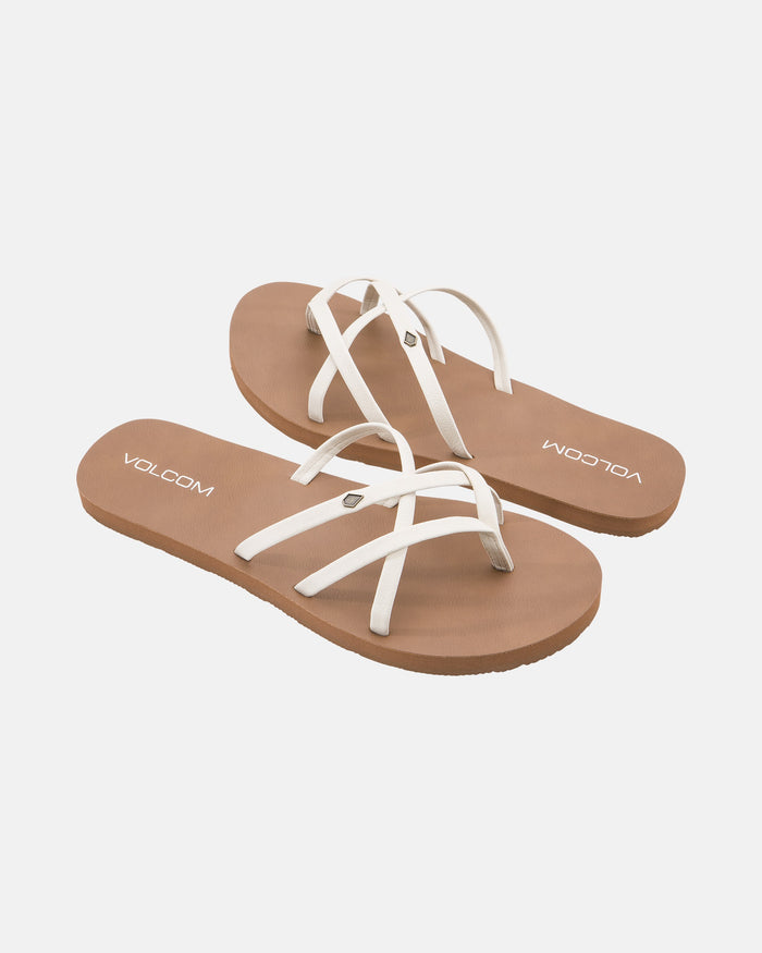 The Women's New School II by Volcom is a pair of brown flat sandals featuring white synthetic leather crisscross straps, Recliner Comfort Foam footbed, and VOLCOM branding—all shown on a plain white background.