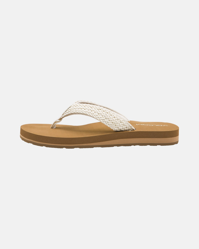 The Volcom Women's Oasis Sandals feature a brown flip-flop design with a textured tan sole and a woven white strap, displayed in side profile against a plain white background.