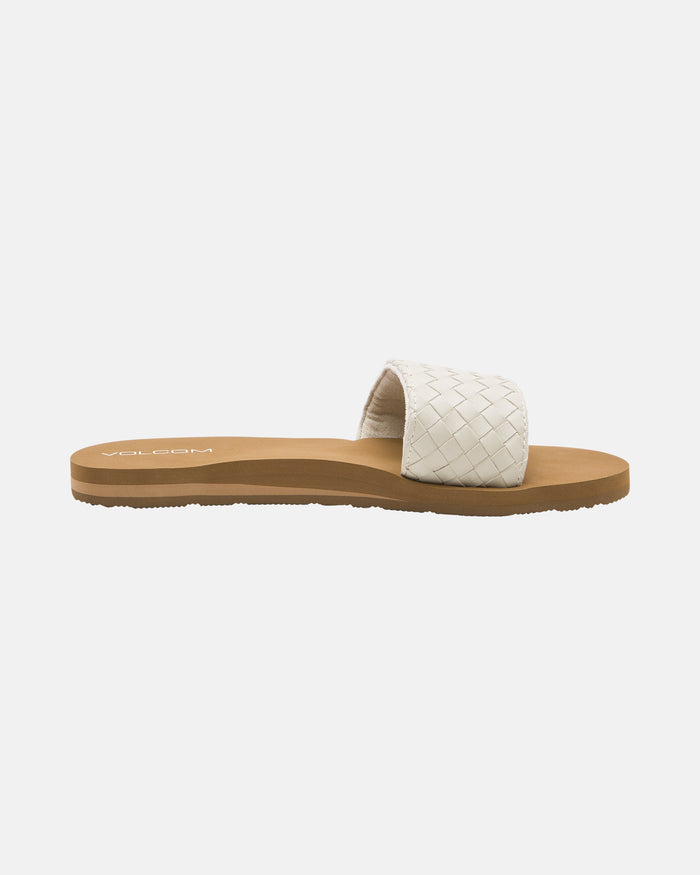 The Volcom Women's Simple Slides Braid Sandals feature a brown flat sole and a white woven strap, displayed on a plain white background.