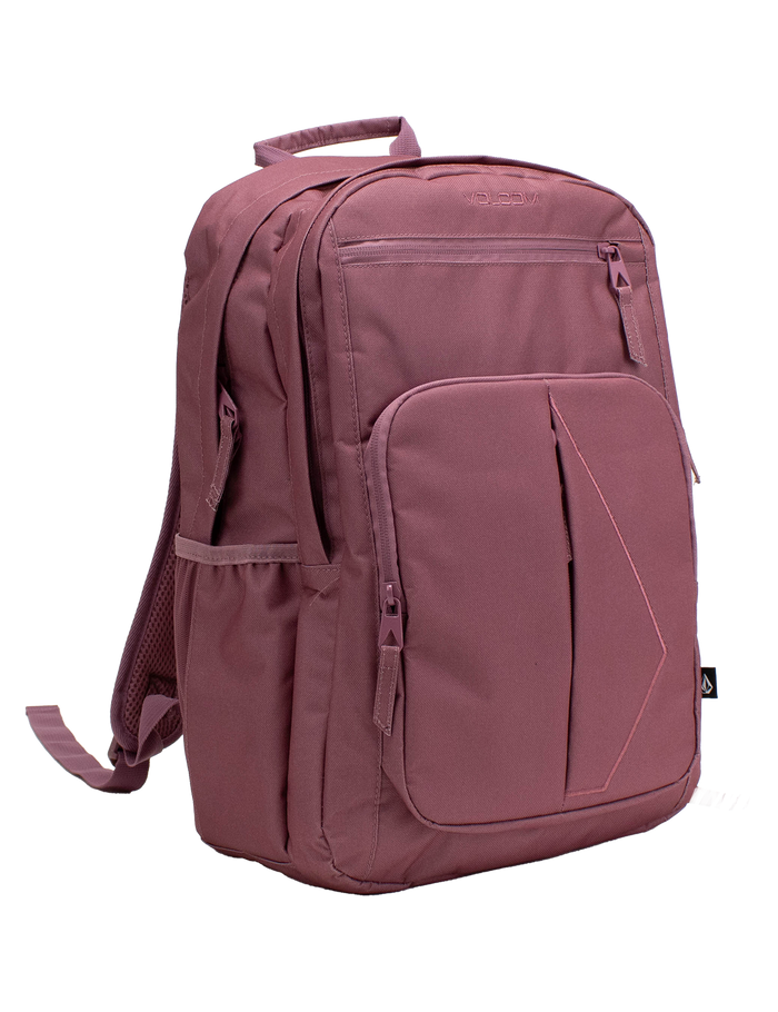 A mauve Volcom Women's Study Buddy Backpackq featuring multiple zippered compartments, a padded laptop sleeve, a side pocket, a front handle, and adjustable shoulder straps, displayed on a white background.