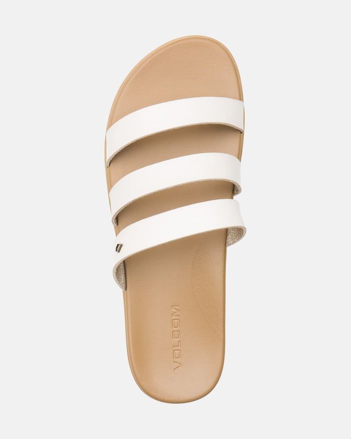 The Volcom Women's Sunseeker Sandals feature a tan base with three white horizontal straps and "VOLCOM" embossed on the footbed, shown from above against a light background.