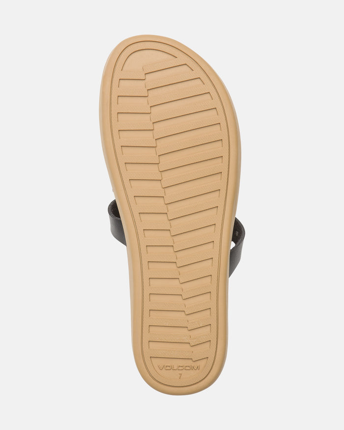 The image shows the sole of the Women's Sunseeker Sandals by Volcom, featuring a tan, textured bottom with horizontal grooves for grip and “Volcom” plus shoe size 7 embossed near the heel.