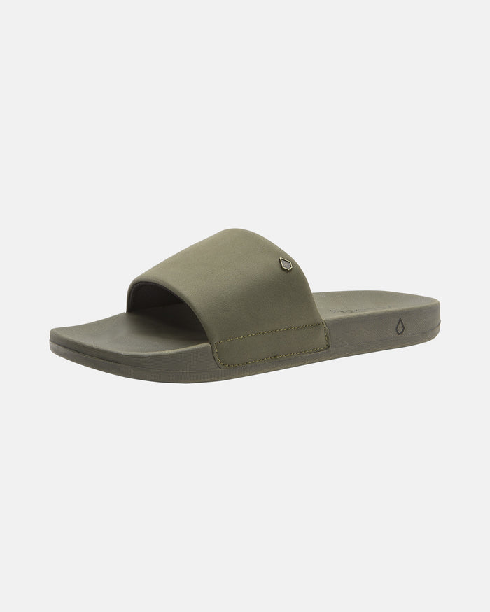 The Volcom Women's Volcation Slides feature an olive green wide strap and flat sole, offering everyday comfort and effortless style—perfect summer sandals shown on a white background.