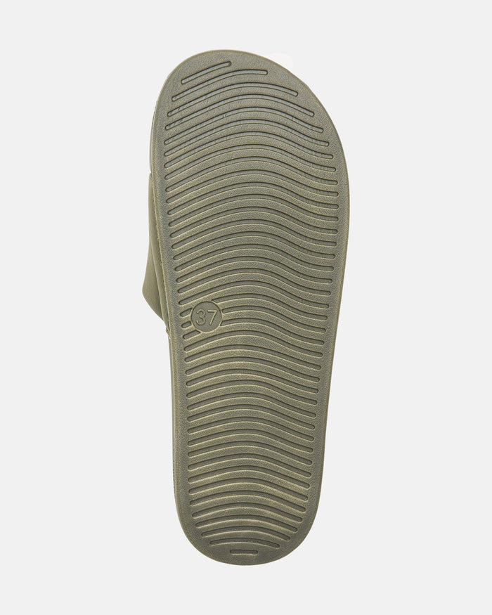 The image shows the sole of Volcom Women's Volcation Slides, featuring curved horizontal grooves for grip and a small circle with the number 37 near the arch, combining signature Volcom style with everyday comfort.