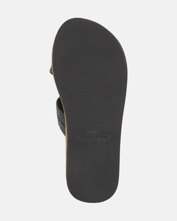 The bottom view of the Women's Volcom Double Cross Sandals by Volcom shows a black sandal with a textured rubber sole featuring fine horizontal grooves for traction.