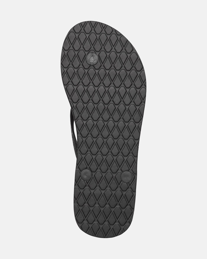The bottom of the Volcom Women's Volcomotion Wos Hawaii flip-flop sandal features a black, diamond-patterned textured sole with three circular plugs.