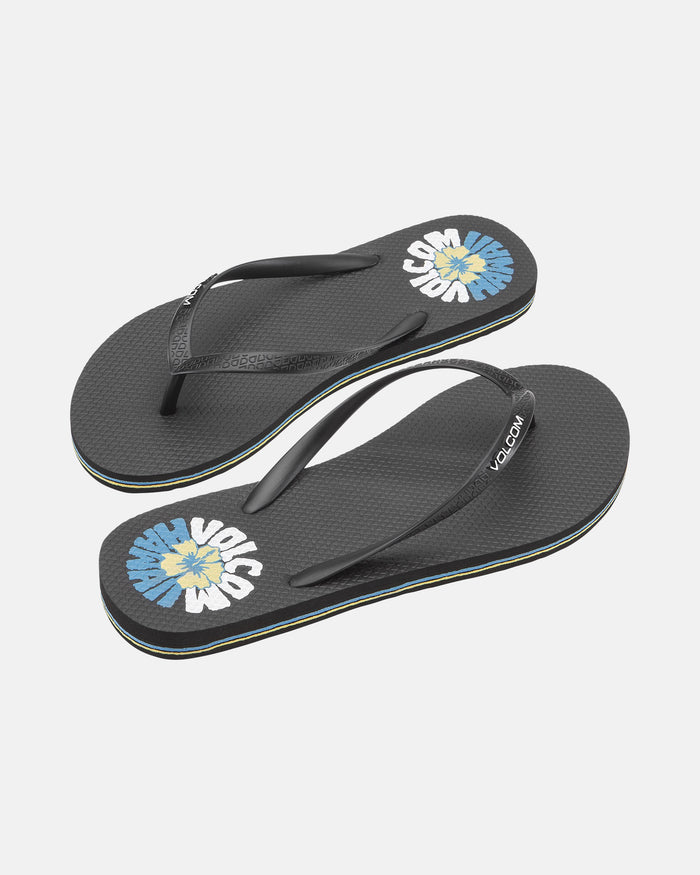 The Volcom Women's Volcomotion Wos Hawaii flip-flops feature black straps, a blue and white flower graphic, “VOLCOM” branding on the footbed, and subtly textured black soles.