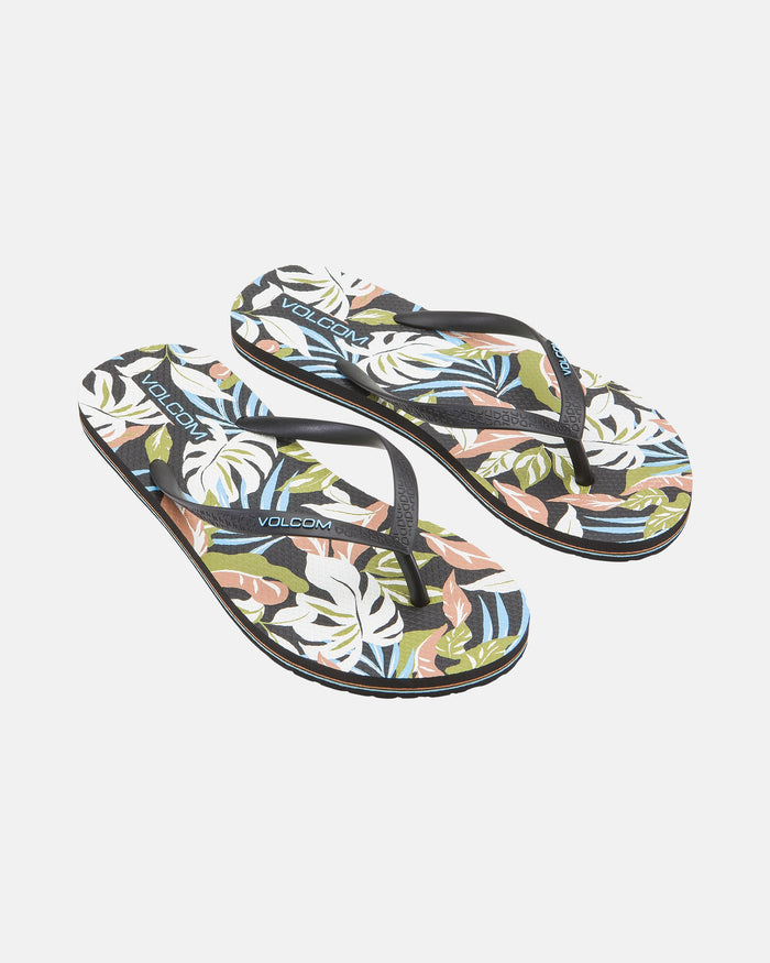 Women's Volcomotion Womens flip-flops by Volcom feature black straps and a tropical leaf pattern in green, white, pink, and blue on the soles—ideal summer sandals for everyday comfort, shown against a white background.