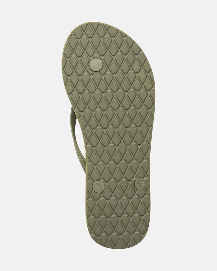 A single Volcomotion Womens flip-flop by Volcom in olive green, sole facing up to show a diamond-patterned tread and two round plug attachments.