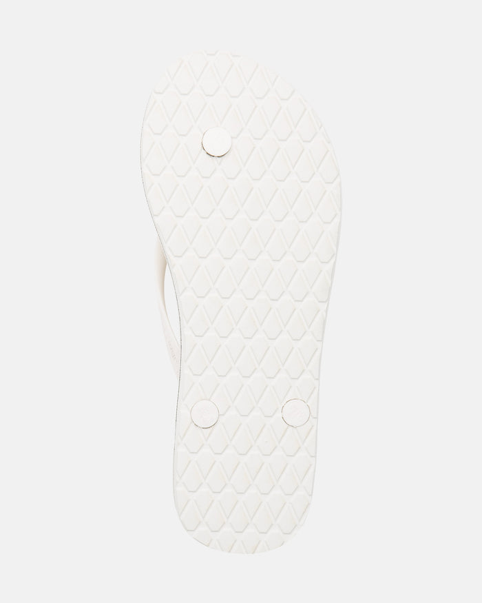 The image shows the white sole of the Volcom Volcomotion Womens flip-flop, featuring a textured diamond pattern and three round plugs on the bottom.