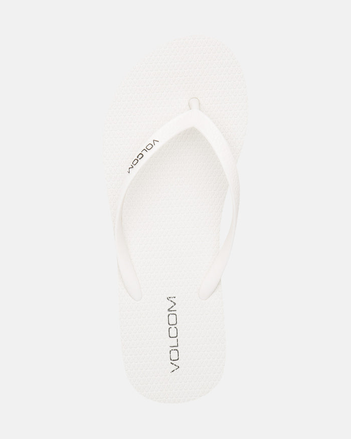 A single Volcomotion Womens white flip-flop sandal by Volcom, featuring the brand name in black on the footbed, displayed against a plain white background.