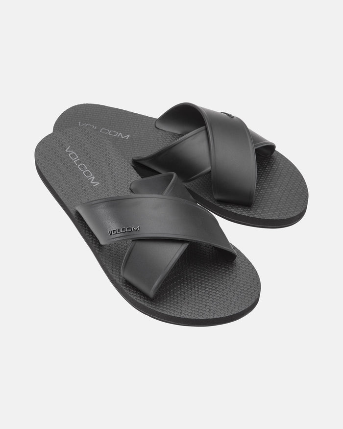 The Women's Volcomotion Strap Sandals by Volcom feature black crisscross straps and textured soles, with the brand name visible on the straps and footbeds, displayed against a plain white background.
