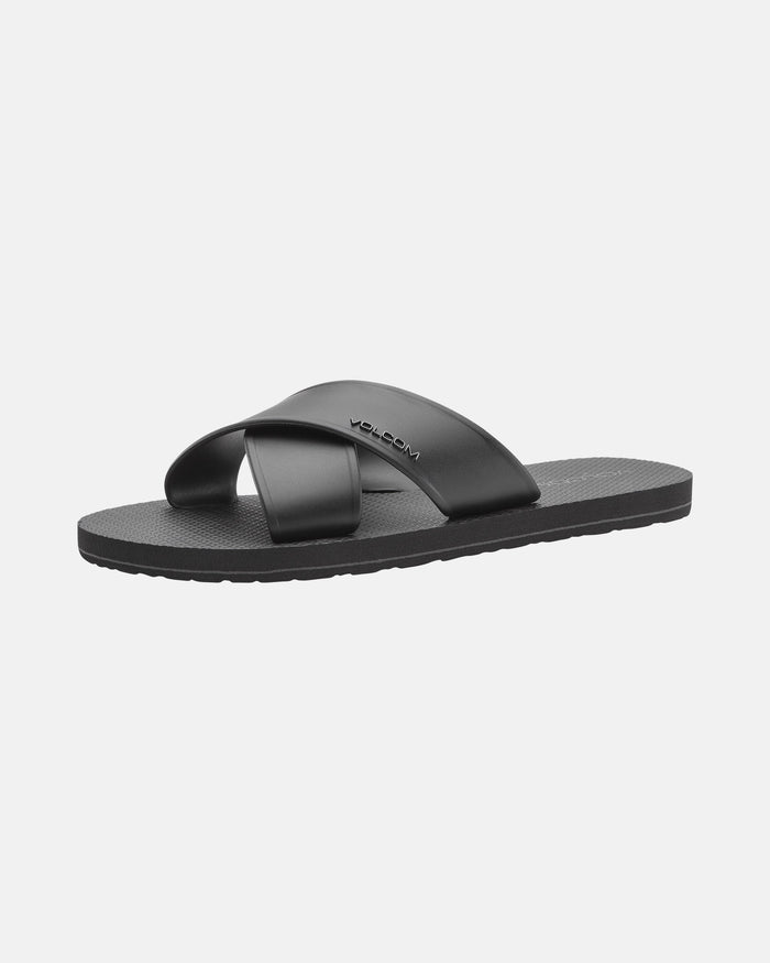 The Women's Volcomotion Strap Sandals by Volcom are black slides with a textured sole, featuring a wide strap with the Volcom logo and an additional diagonal support strap across the top.