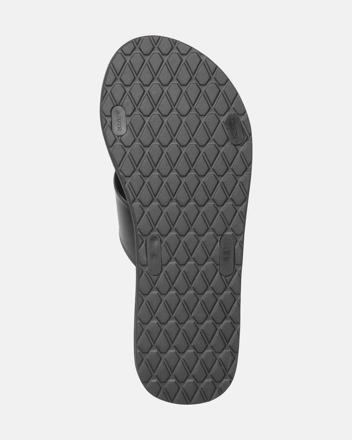 The image shows the black textured rubber sole of the Women's Volcomotion Strap Sandals by Volcom, viewed from the bottom with a diamond pattern and small rectangular grip sections.