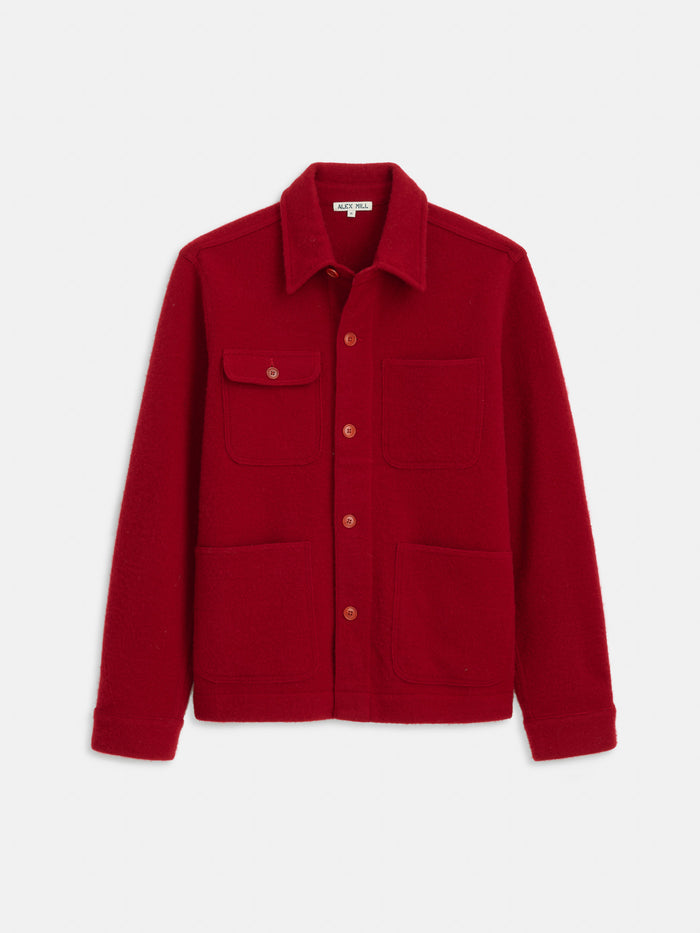 The Work Jacket In Merino Wool Knit is a red jacket with a collar, one buttoned chest pocket with flap, and two lower front pockets, shown on a white background.